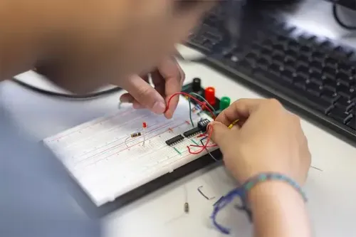 A student works on a circuitboard. 